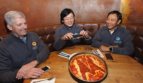 杨元庆在收购完成后很高兴，用手机拍照带有Moto Logo的披萨